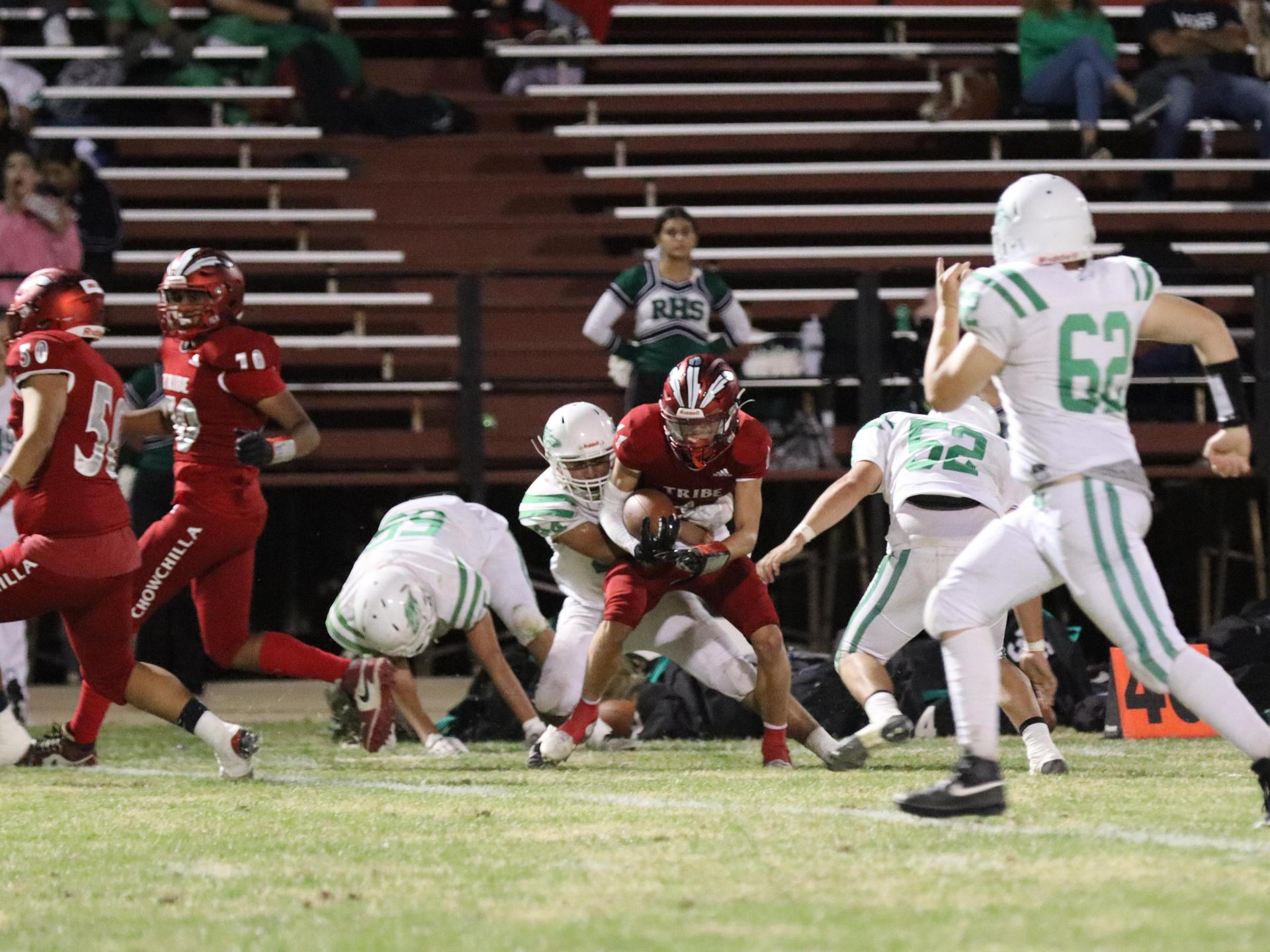 varsity football players in action against Riverdale