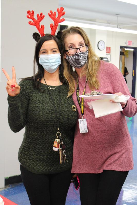 Teaching holding up peace sign posing with teacher holding plate of food