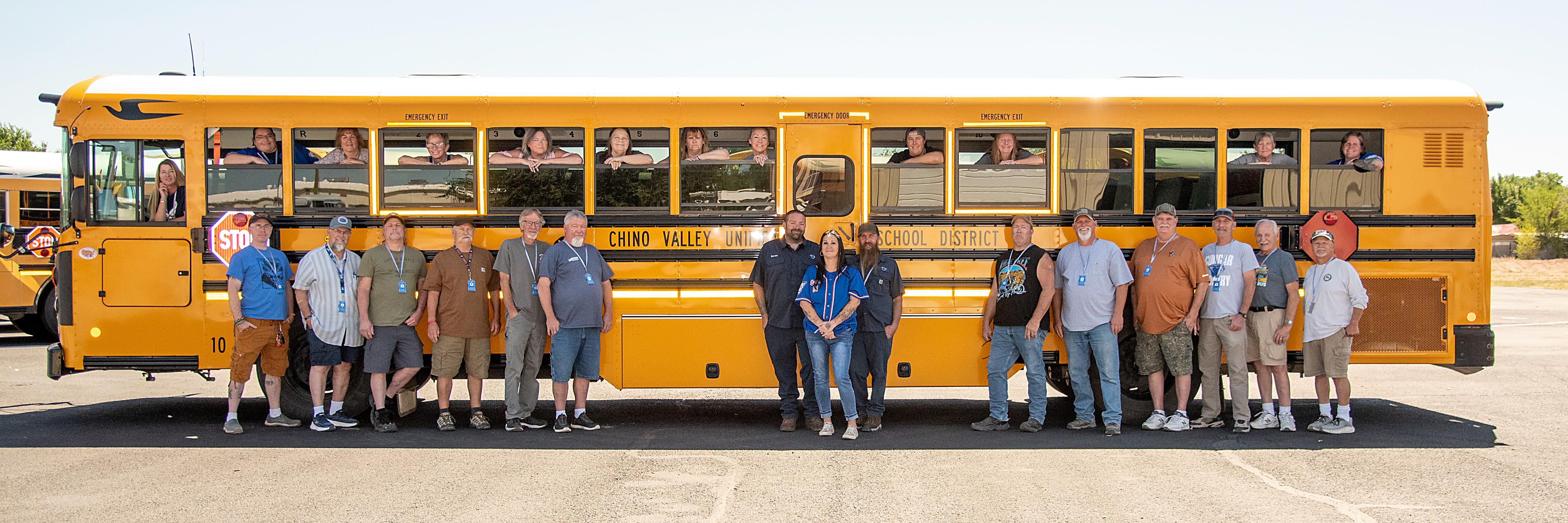 group photo of all transportation staff with school bus