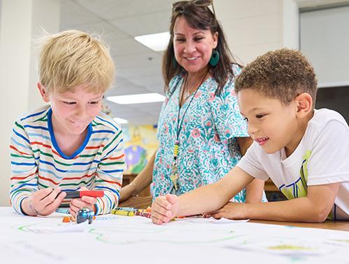 James River Day School kindergarteners experiment with mini-robots.