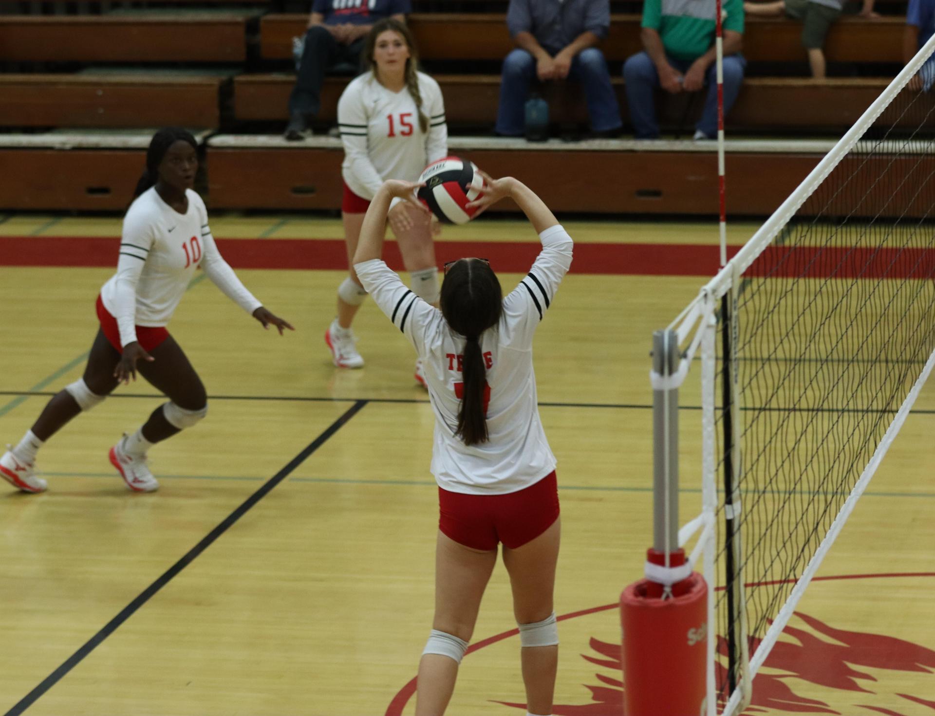 varsity volleyball players in action against liberty