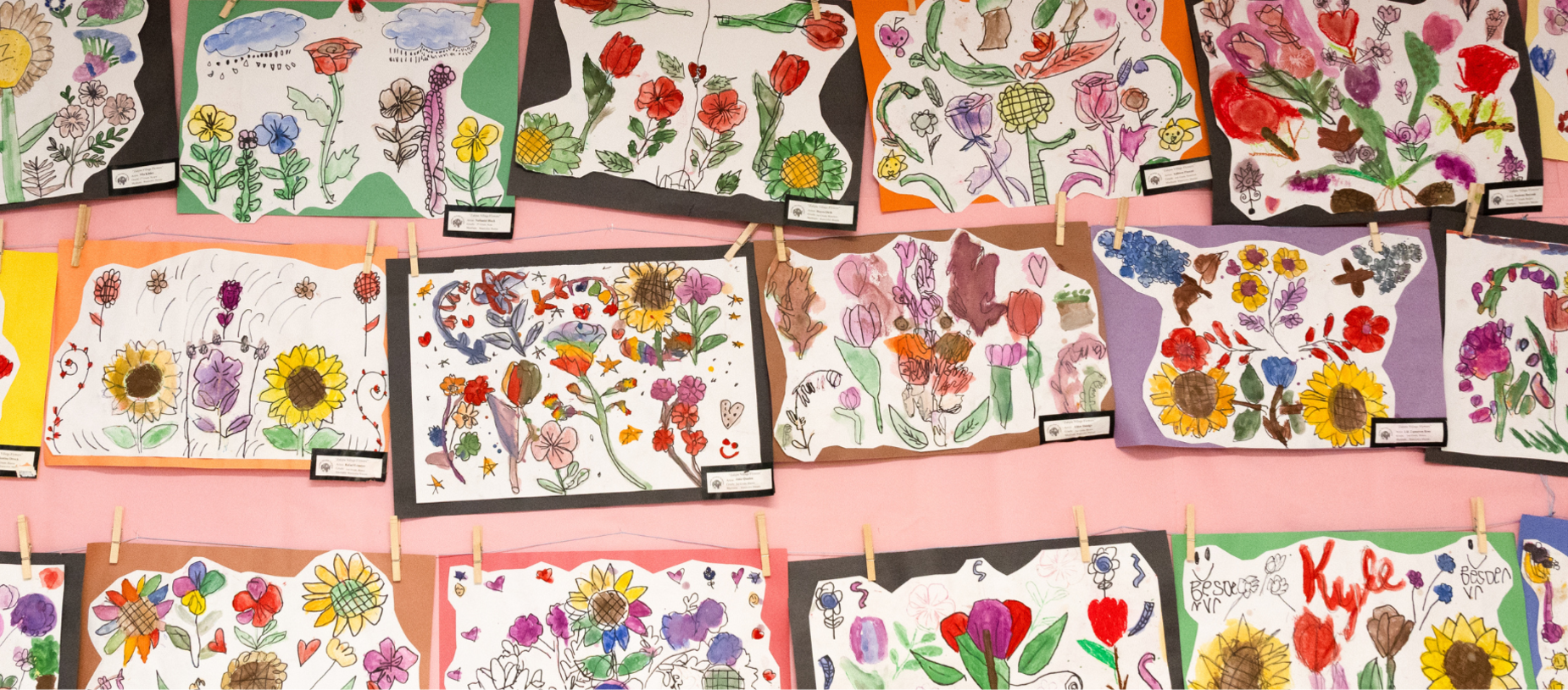 Various floral artworks are hung on a wall, showcasing students' creativity.