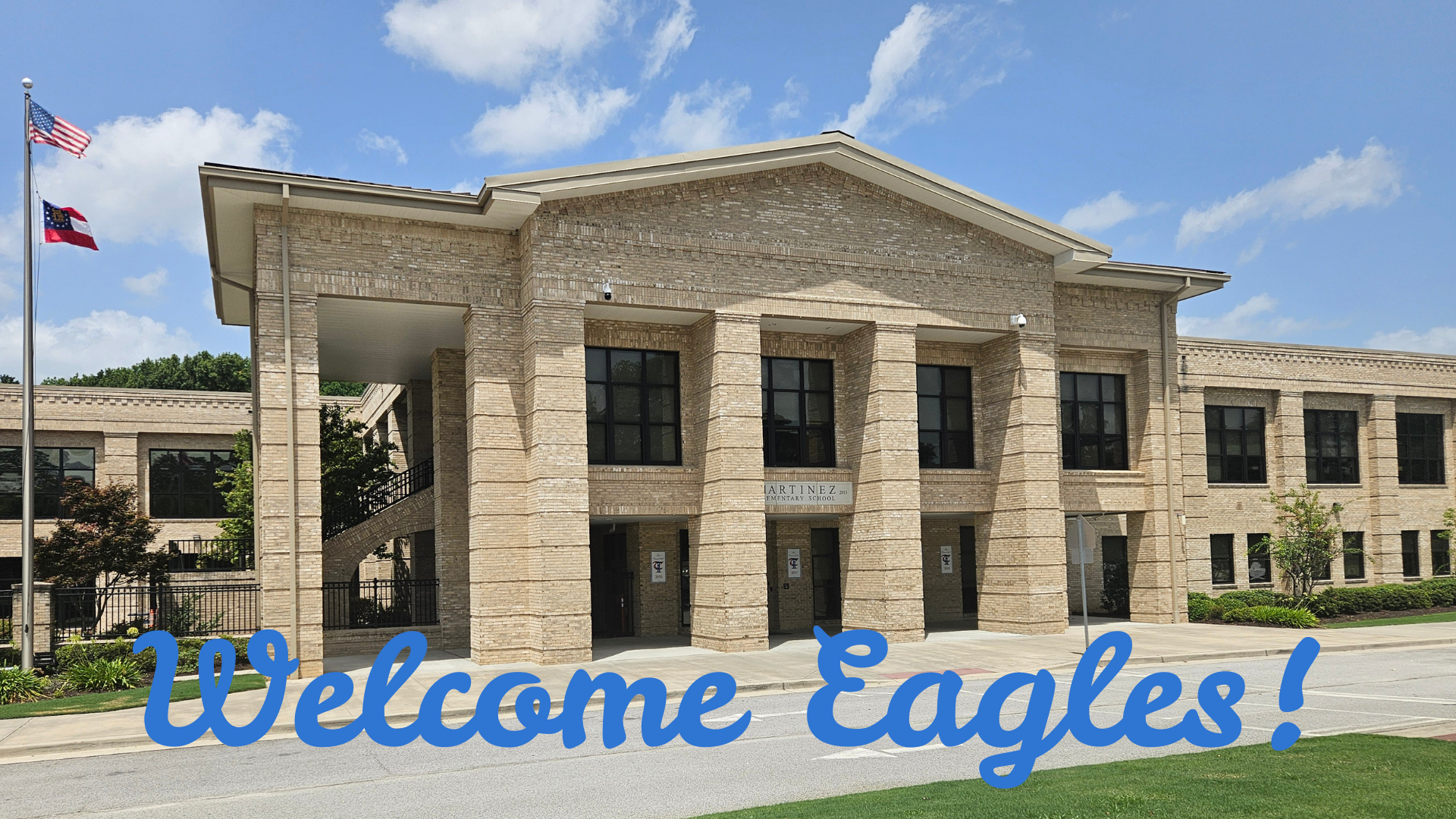 Stone building with large columns, blue sky, and a welcome sign for Eagles.