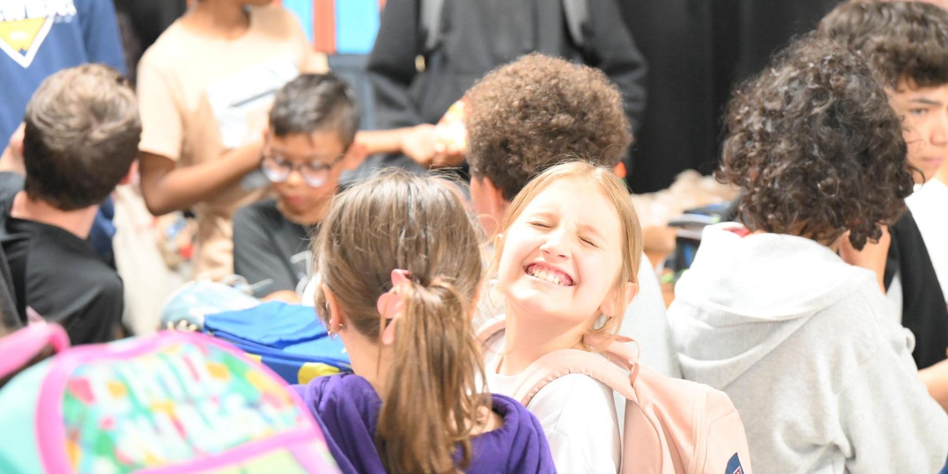 A group of children chatting happily at a busy event.