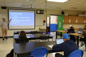 Teacher Jonas Lapointe points to screen with agenda for the day