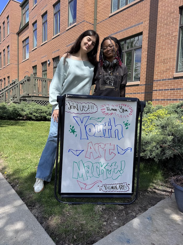 Photo of the two Brooks students with a sign.