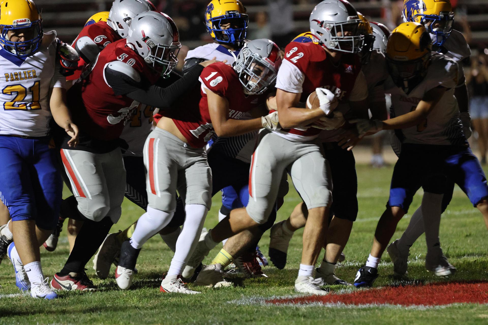 Varsity football players in action against Parlier 122