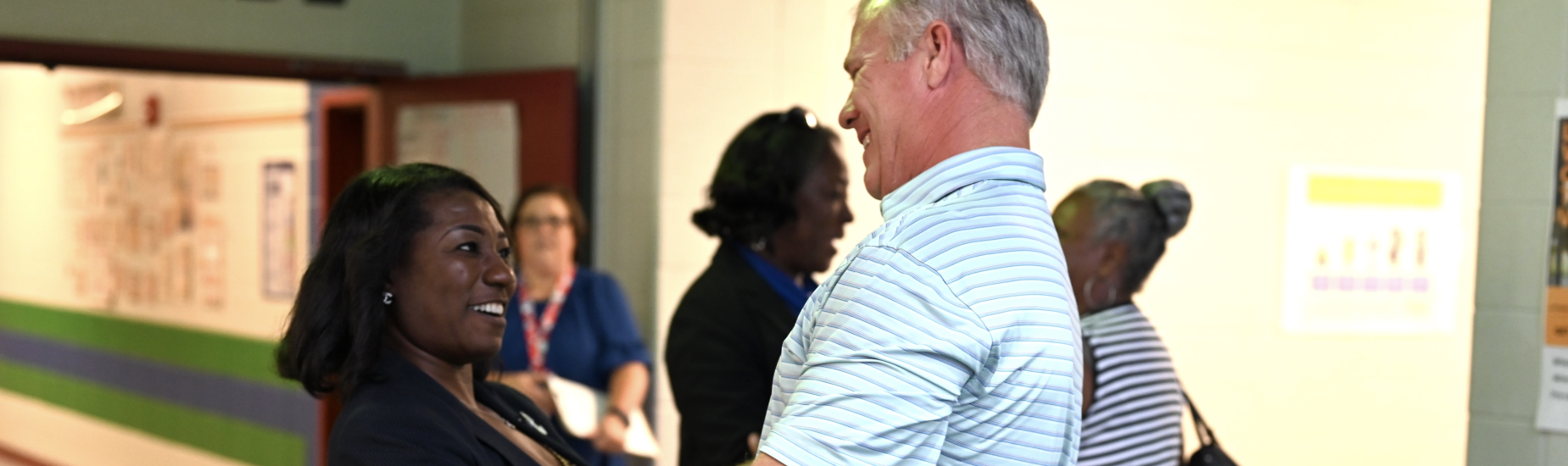 a teacher and coach welcome each other back to school