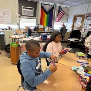 Students in a classroom organzing and folding fabric.
