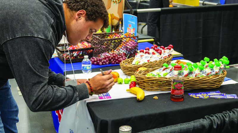 student at the Food Show looking at food