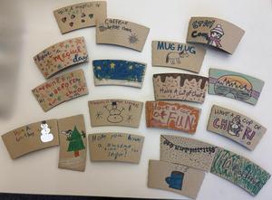 Colorful coffee cup sleeves with various drawings and positive messages.