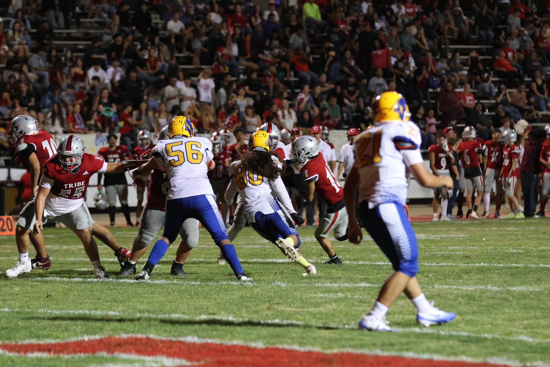 Varsity football players in action against Parlier 64