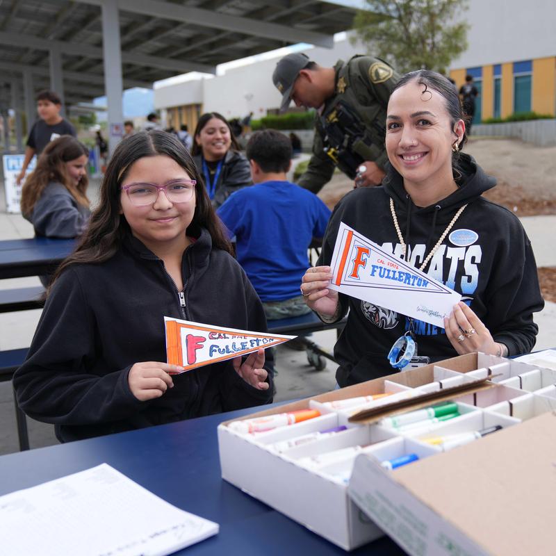 student and staff showing college pennant they created