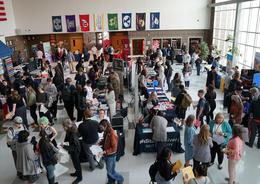 Aerial view of a bustling event with attendees mingling and vendor tables spread out.