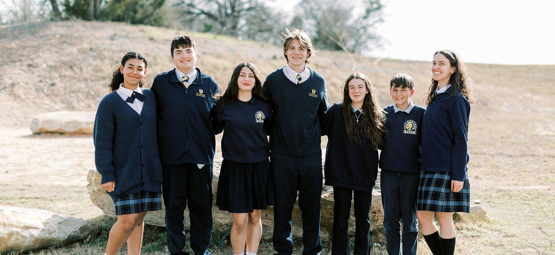 Seven middle and high school students in uniform stand together outside at Plainview Classical Academy
