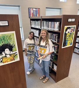Meredith and Brooklyn smile while looking for a book
