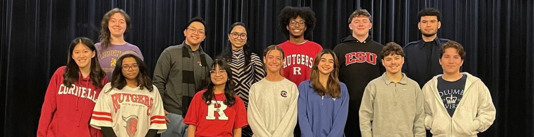 Group of diverse students smiling together on stage.