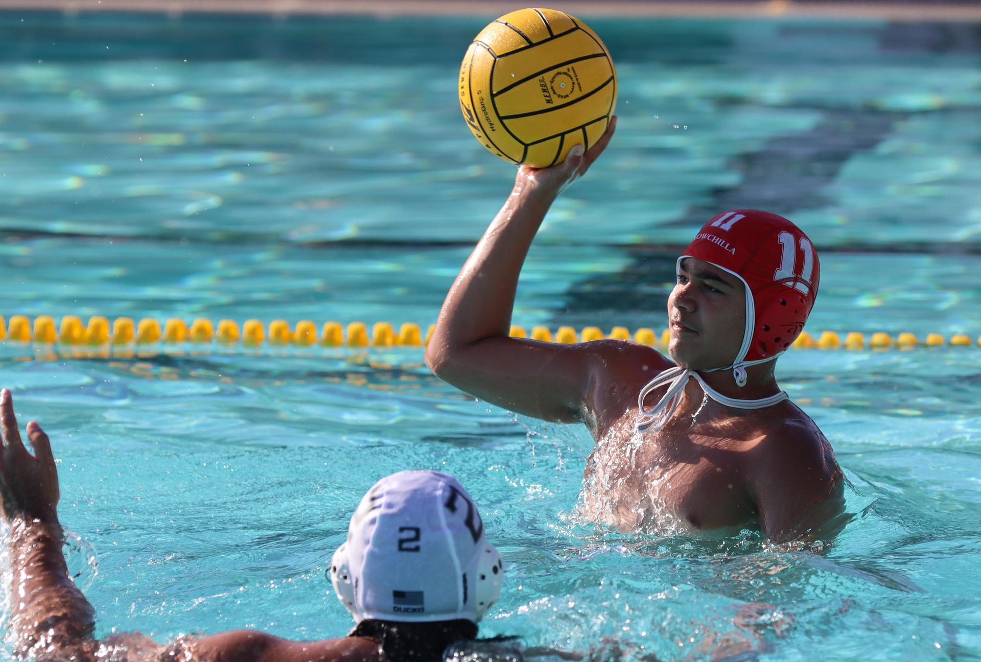 boys water polo players in action against hoover