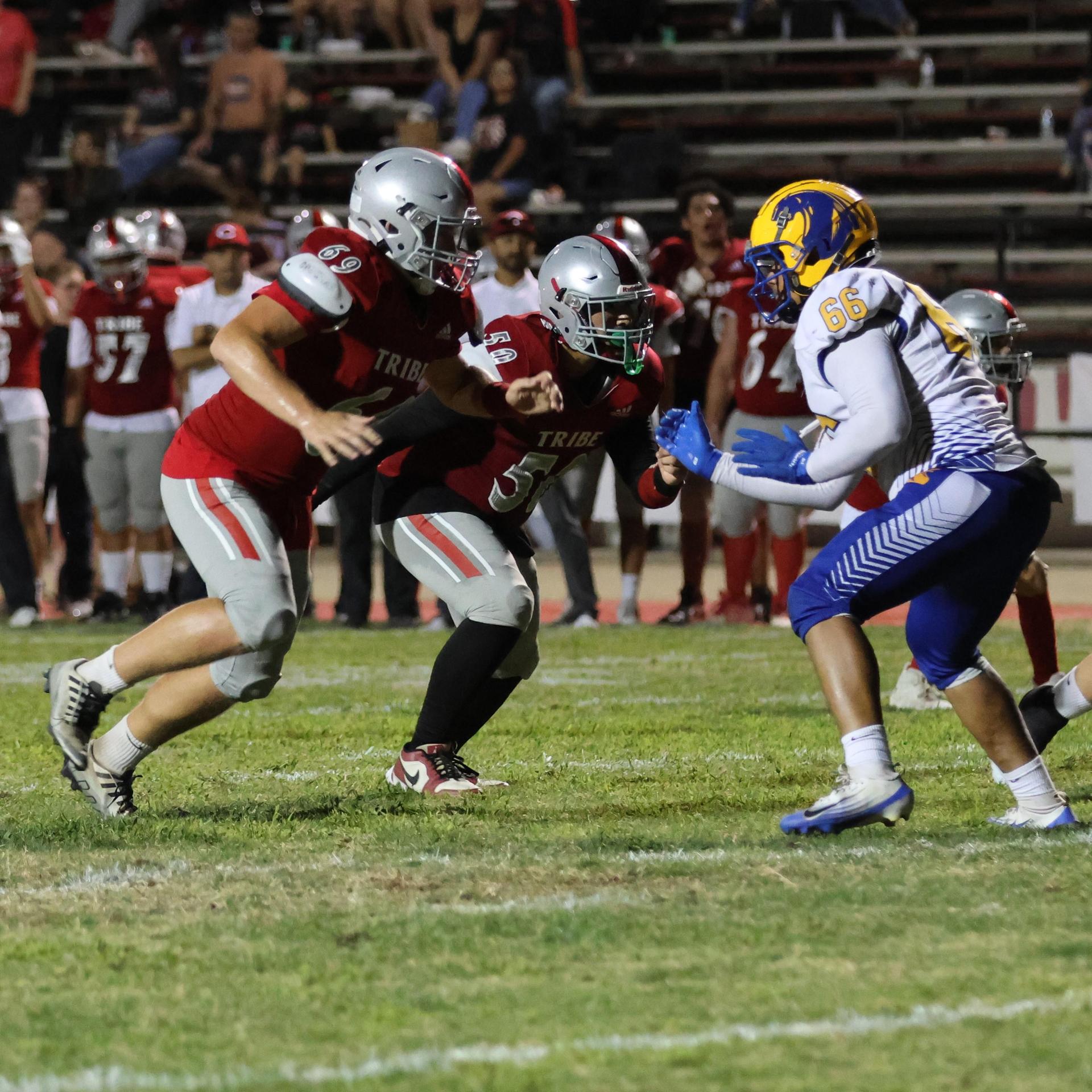 Varsity football players in action against Parlier 129