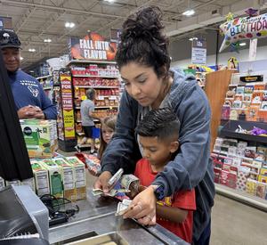 Parent volunteer helping Crestview student at United Supermarkets check-out.