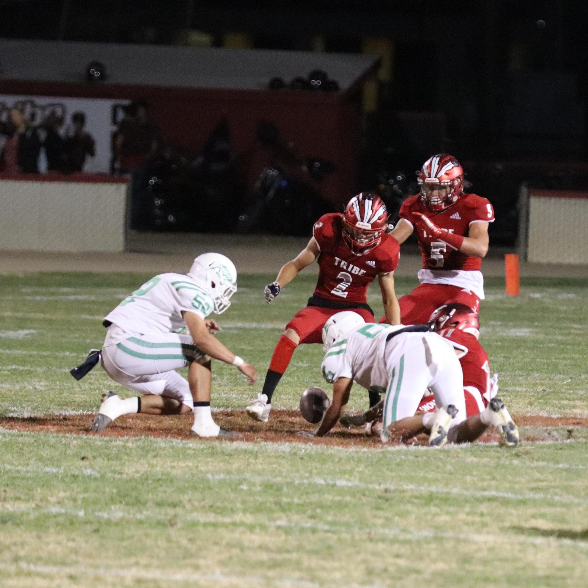 varsity football players in action against Riverdale