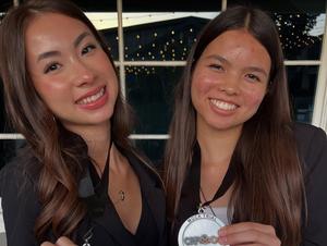 a close up of two mock trial students with their awards