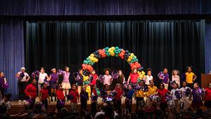 Third grade students perform a cheer at an assembly