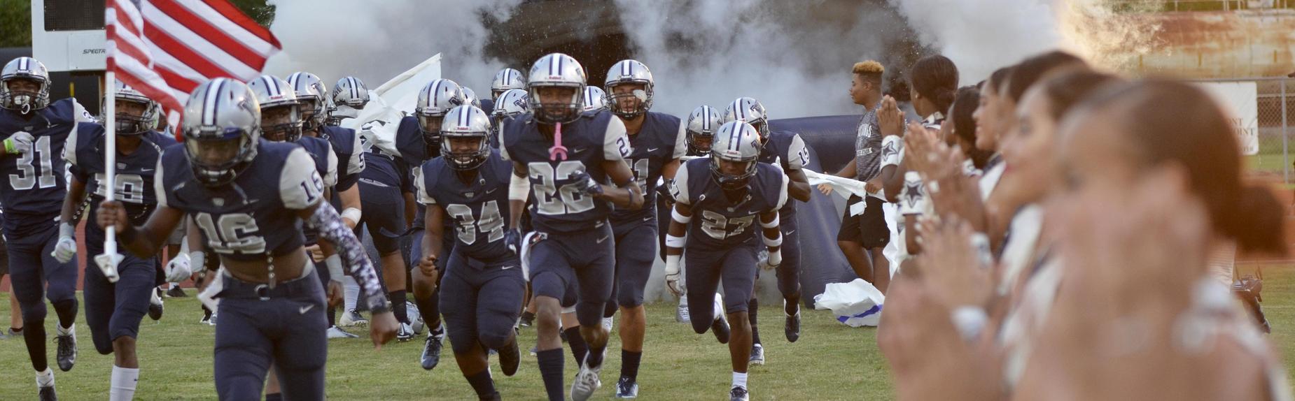 The Mustang football team enters the field.