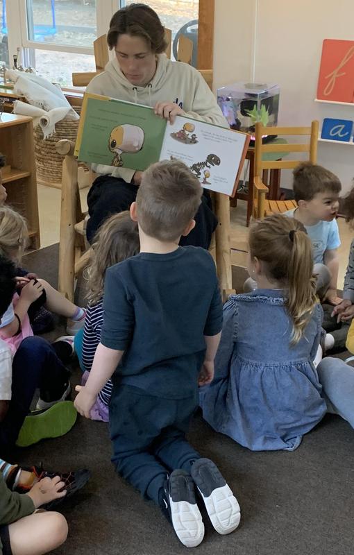 8th year student reading to a group of Primary students