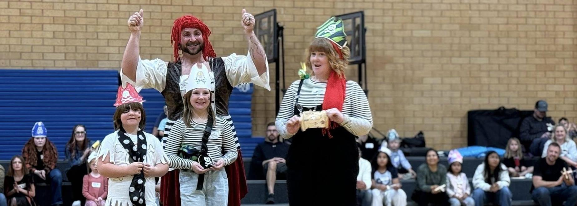 A group of three people dressed as pirates performing in front of a crowd.