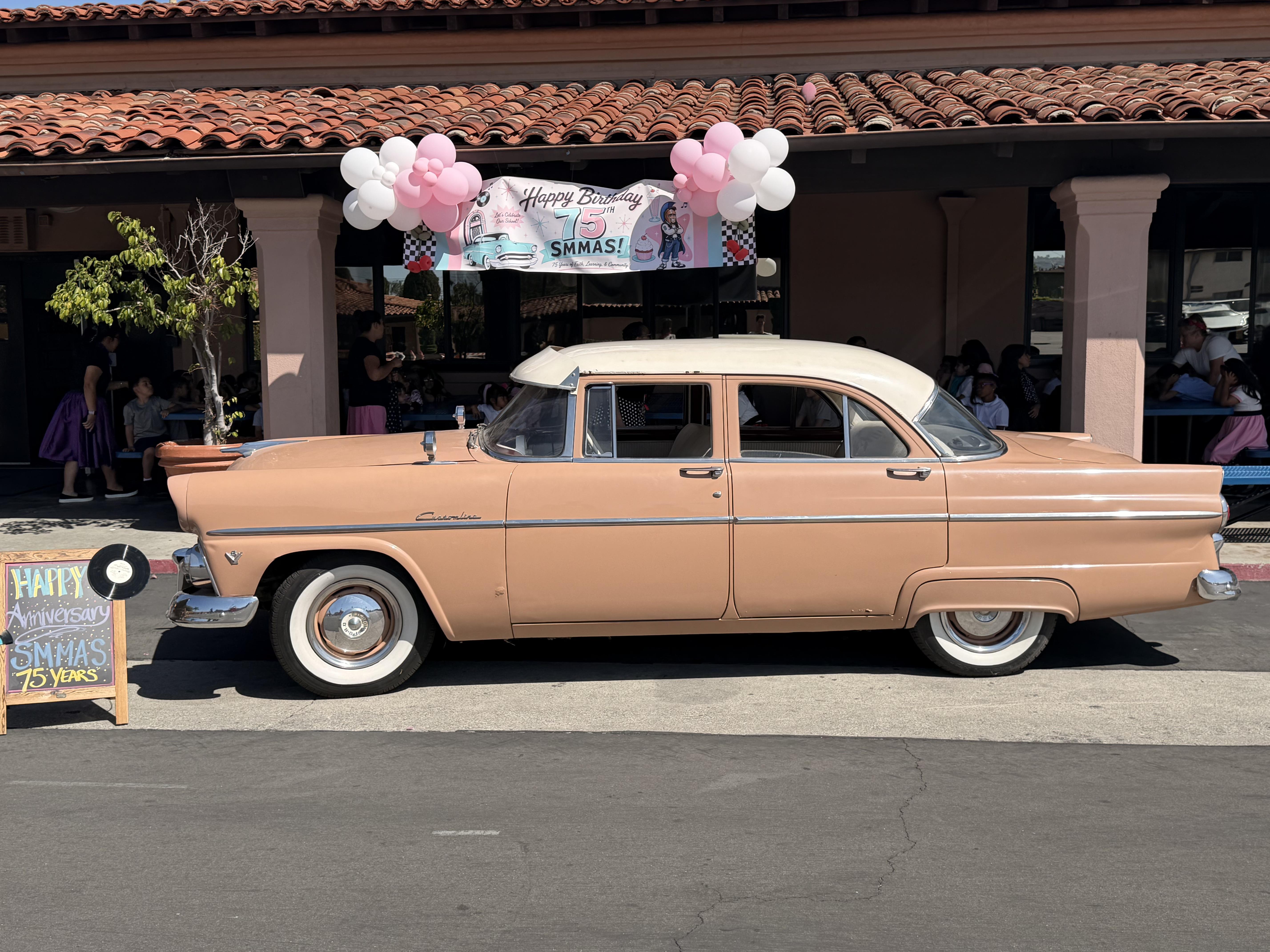 vintage car in front of a school