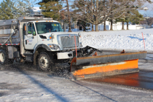 A VDOT snow plow clears snow from a roadway.