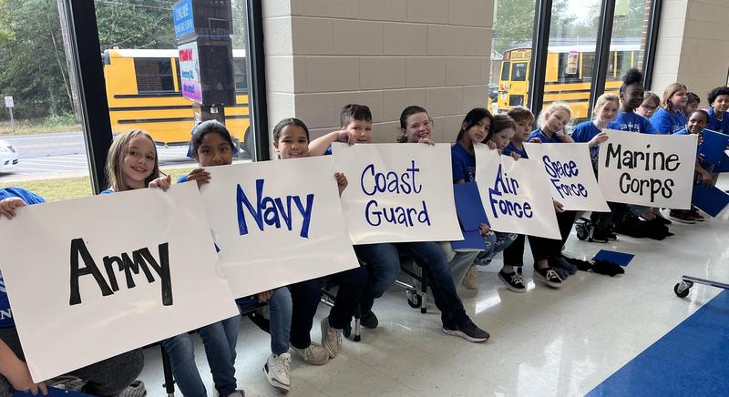 Students hold signs during last year’s Veterans Day program at Congaree Elementary.