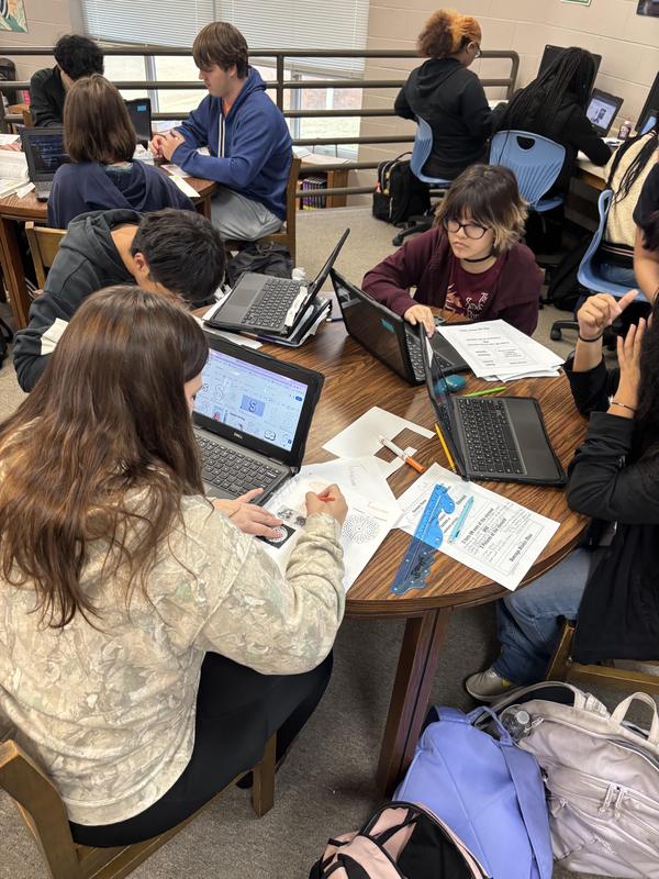 Several tables of students working on their element in the library