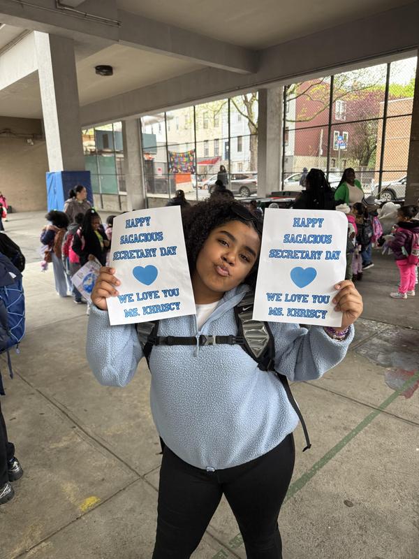 Student holding up signs for the secretary
