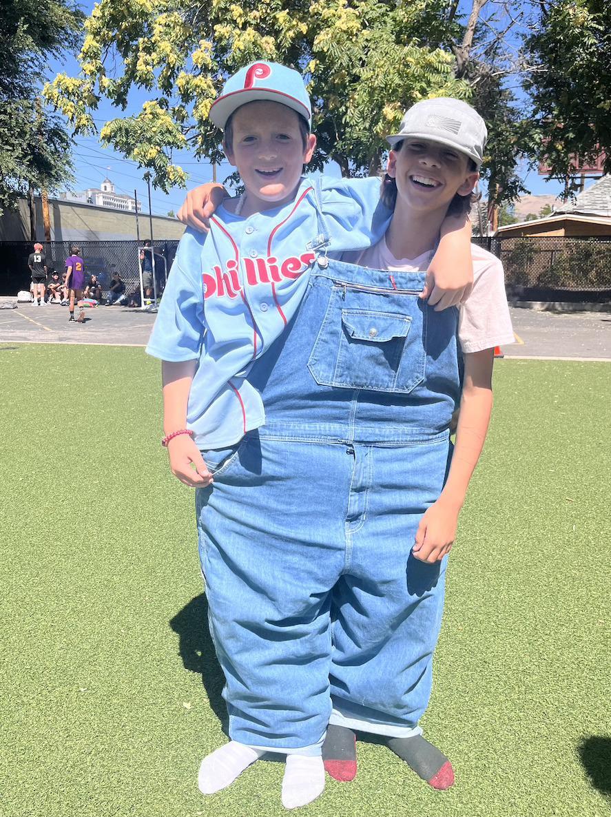 Two kids in large overalls