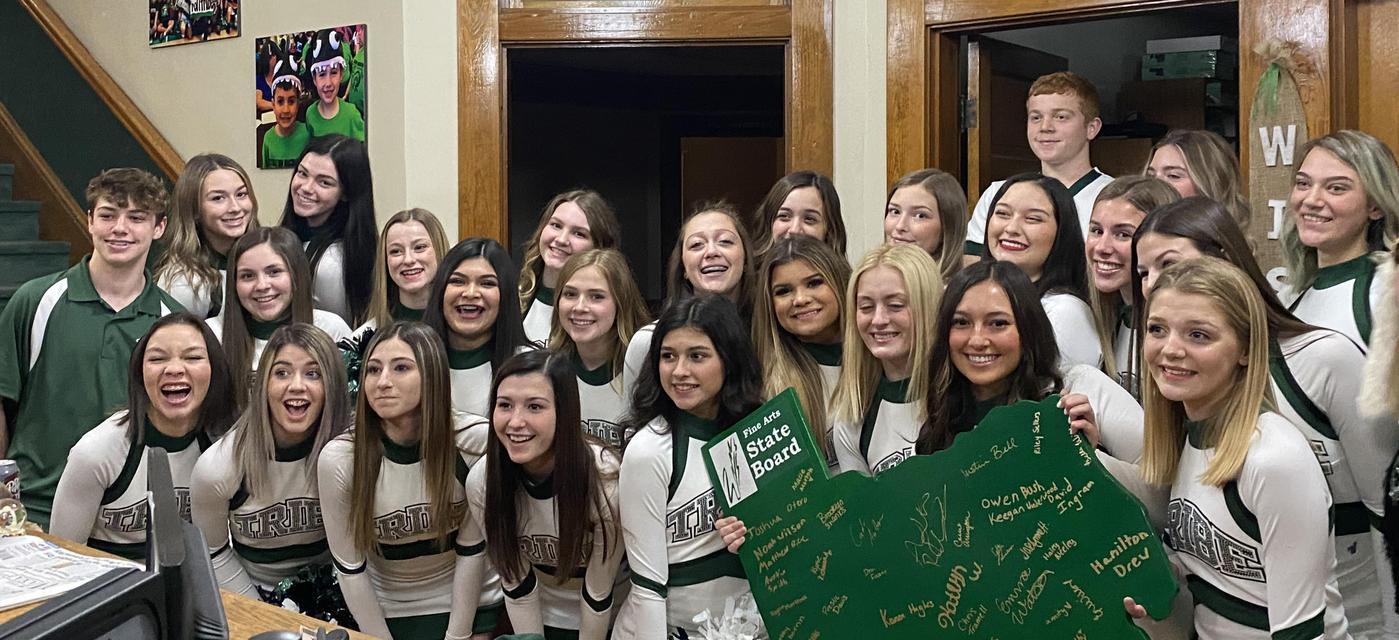 large group of cheerleaders pose together in uniform