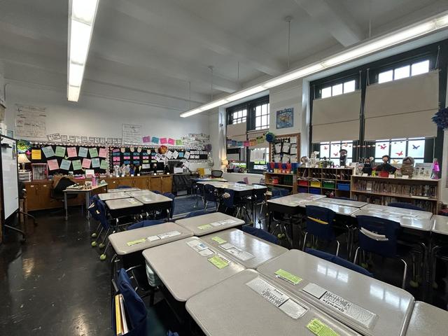 A classroom filled with desks, chairs, and colorful educational displays.