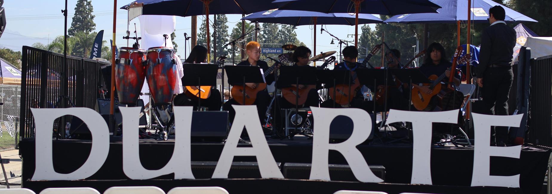 The stage with 'DUARTE' in large letters and musicians performing in the background.