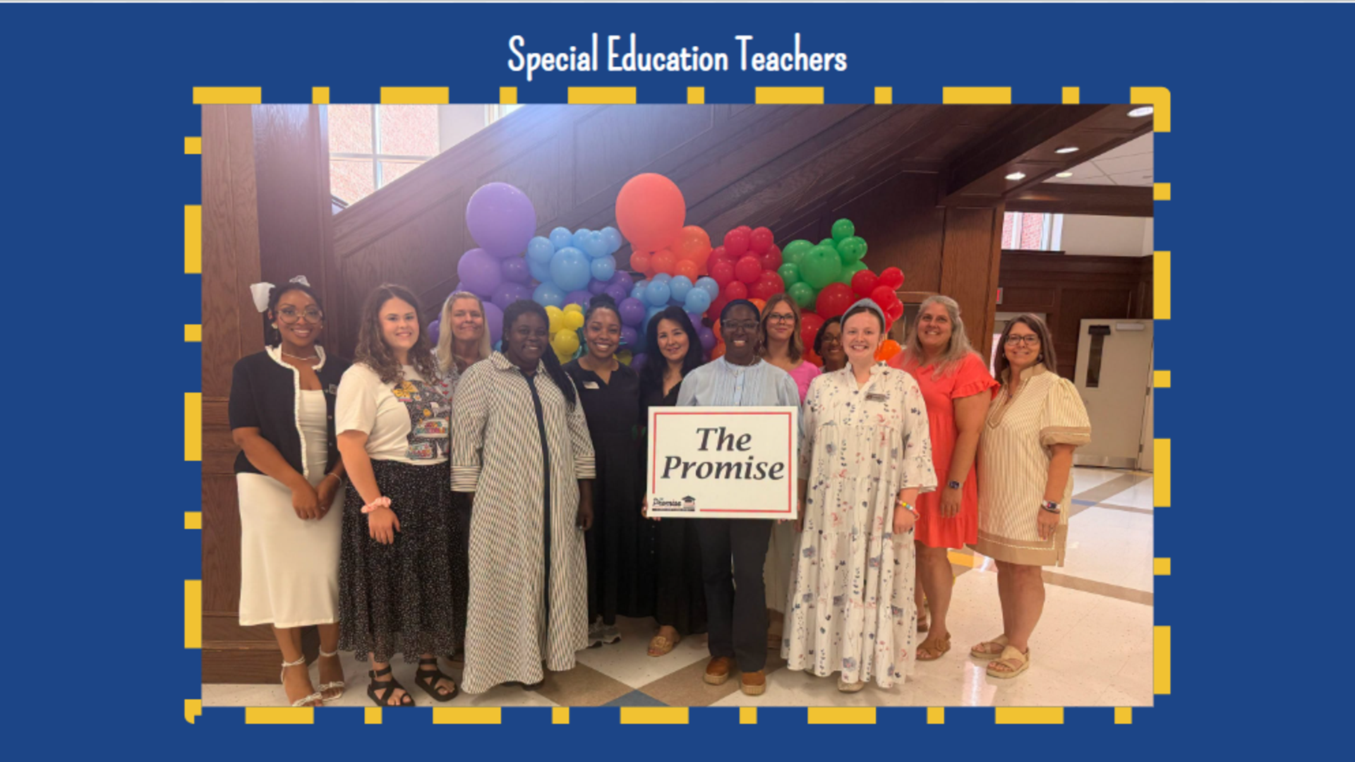 Group of special education teachers holding a sign in front of colorful balloons.