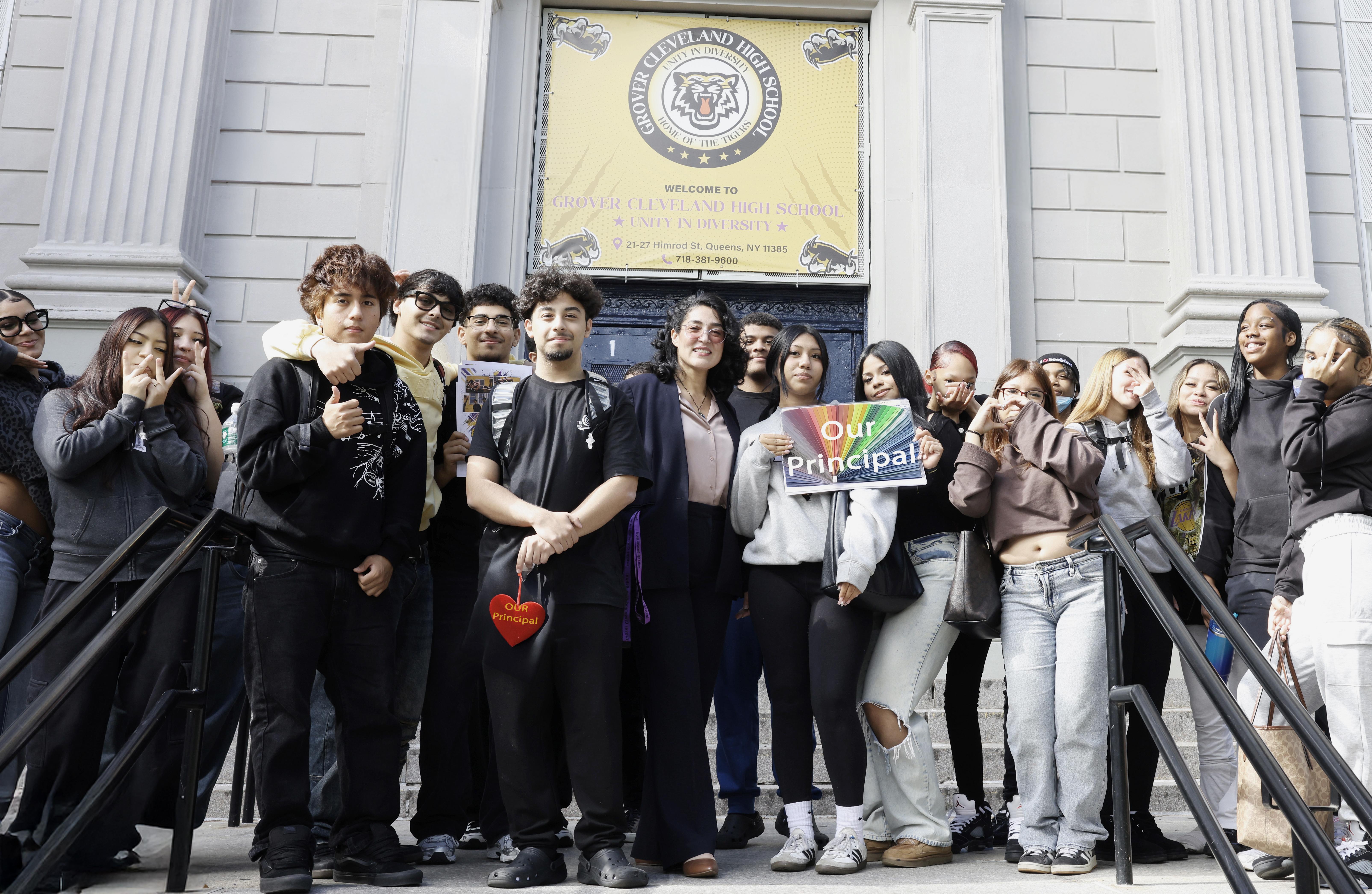 Students posing with pricipal Toro with two posters