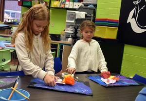 two girls tying a piece of string