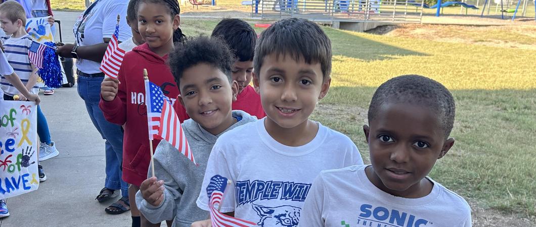 Children smiling holding the American Flag.