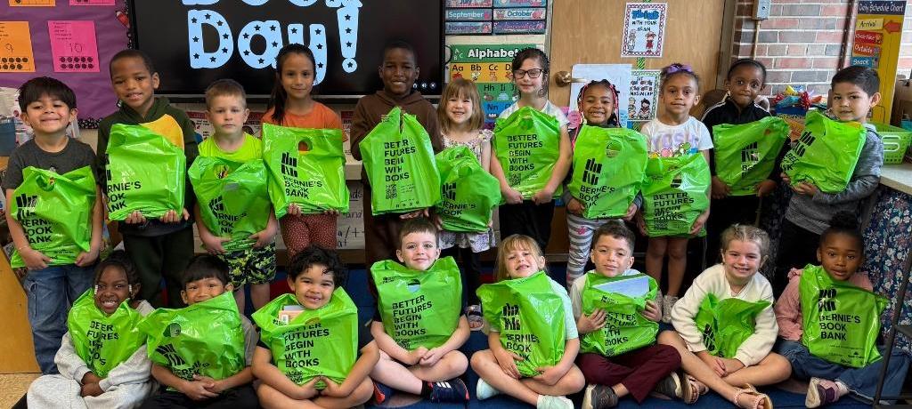 classroom of students hold neon green bags filled with books