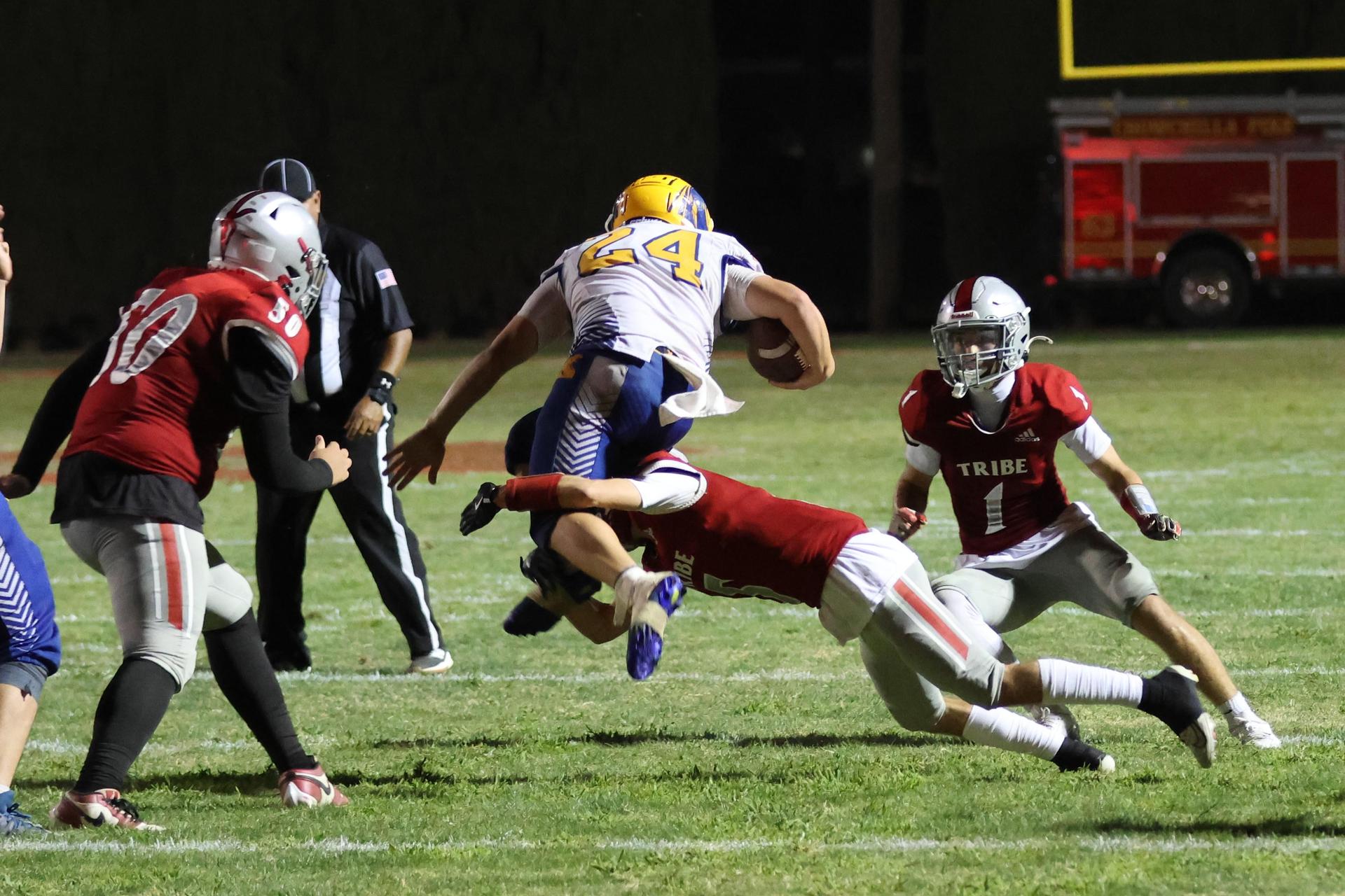 Varsity football players in action against Parlier 78