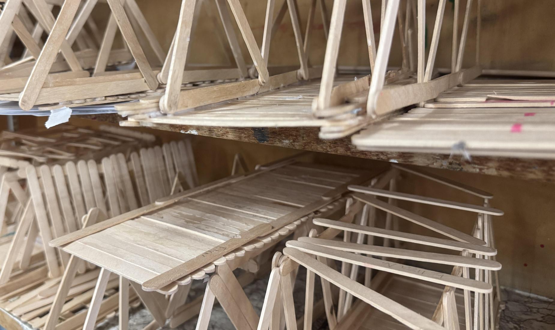 Popsicle stick bridges on shelf in classroom.