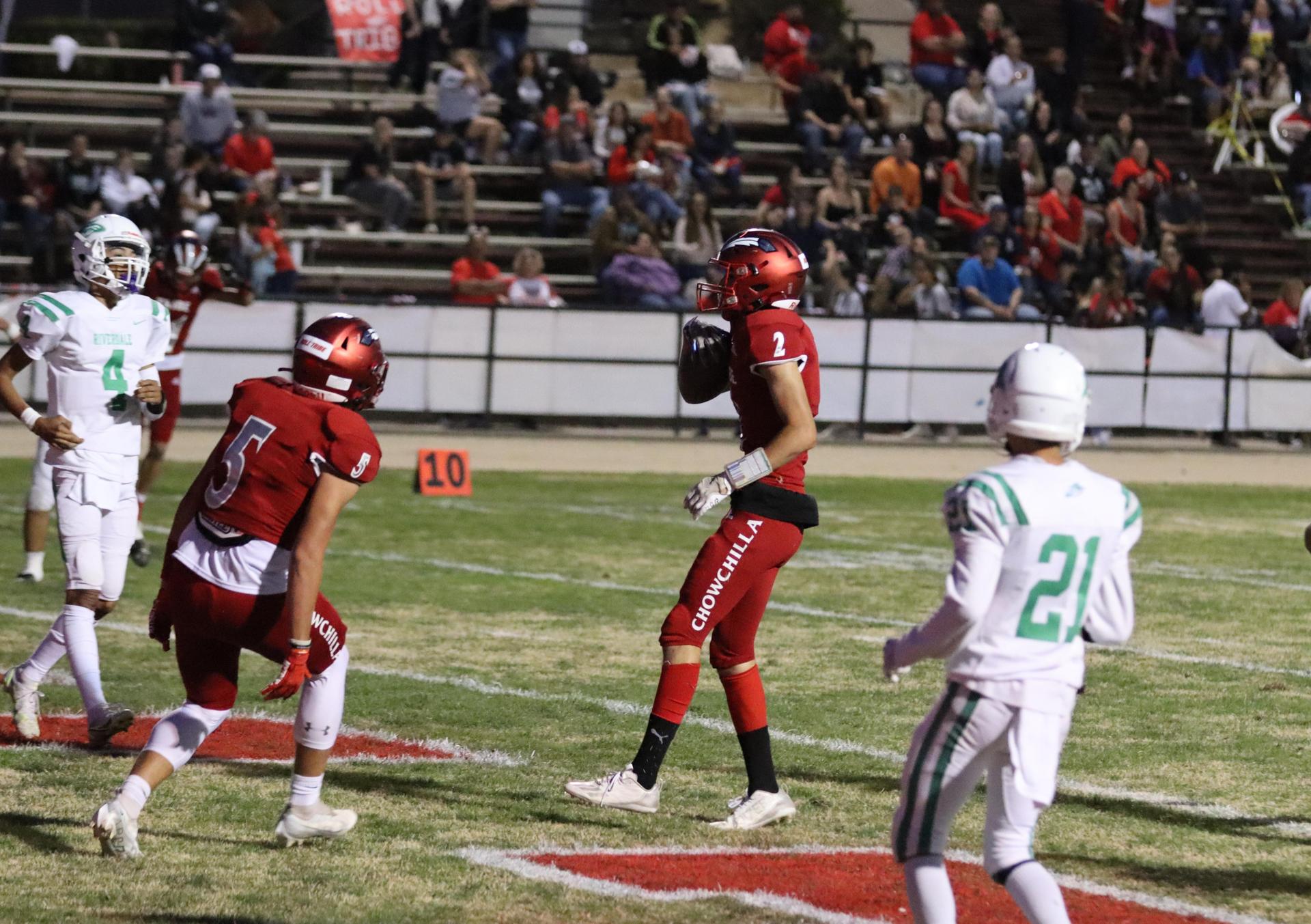 varsity football players in action against Riverdale