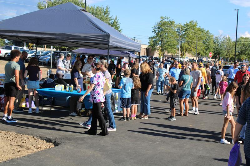 large group of people mingling outside a school