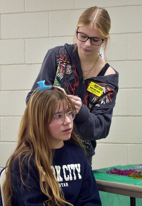 a girl styling another girls hair