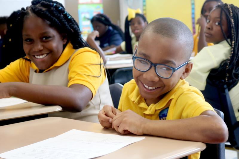 An elementary girl and boy from KBP sitting together at a table on the first day of school